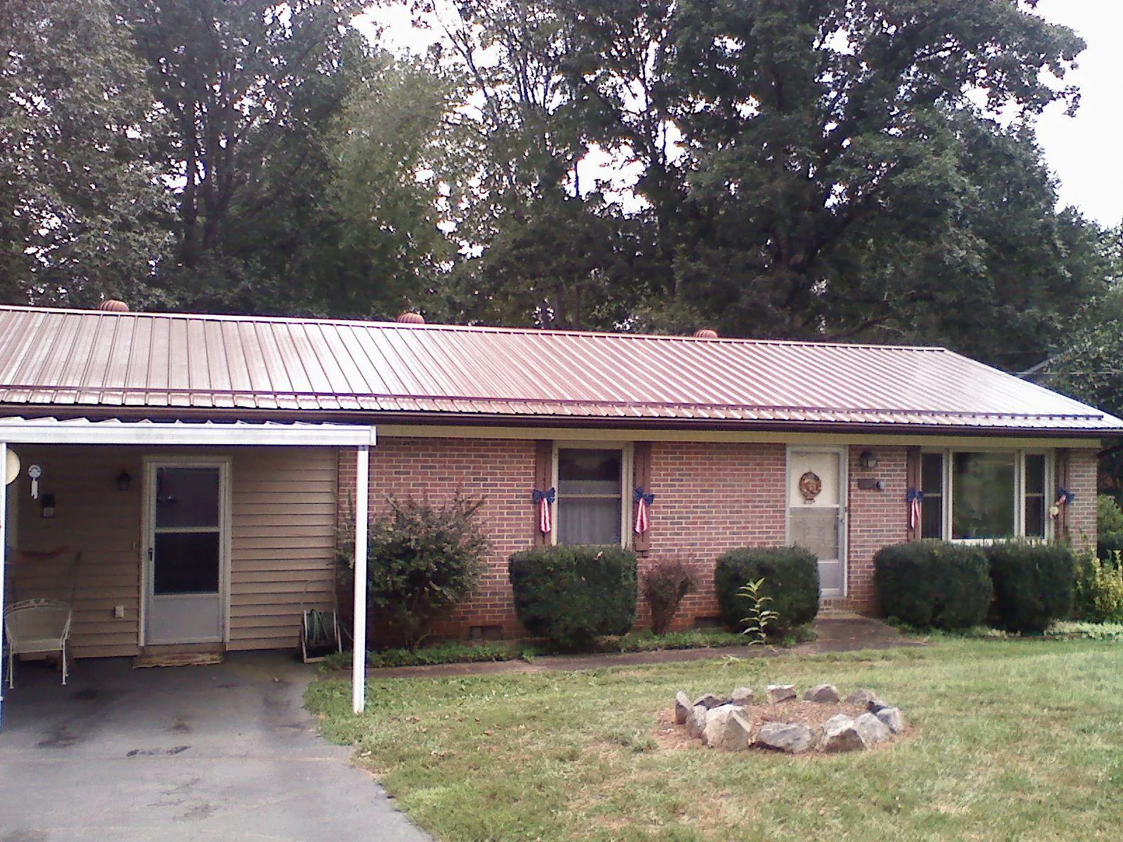 Bronze metal roof and carport on a brick ranch home — Roof Repair work by our crew in Wylie